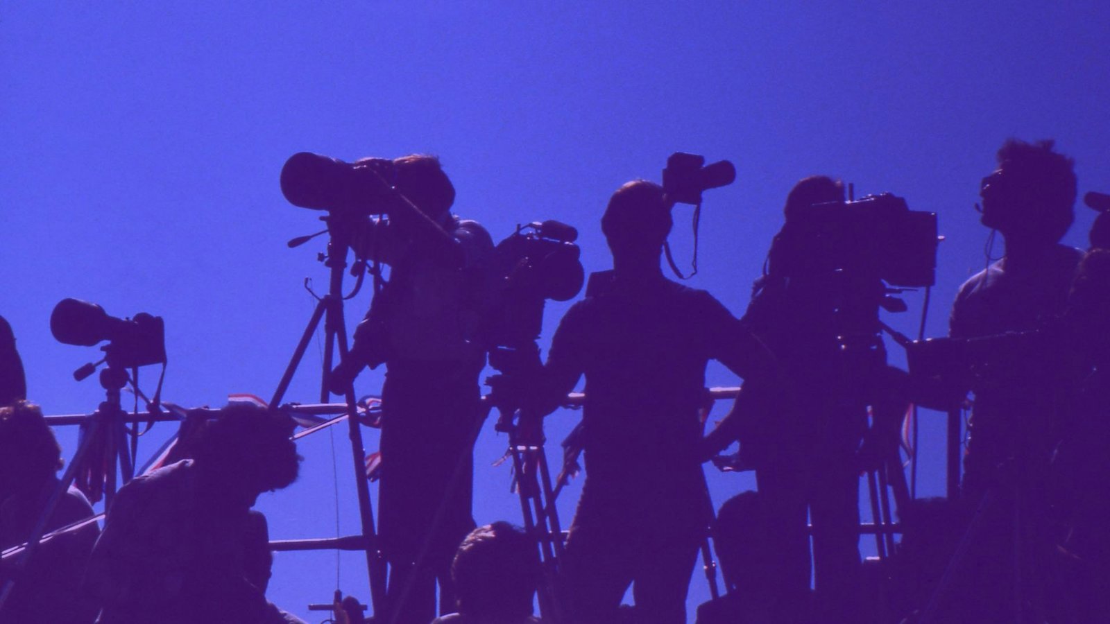 Persfotografen en cameraploegen op een rij, artikel over perslijsten en newsrooms